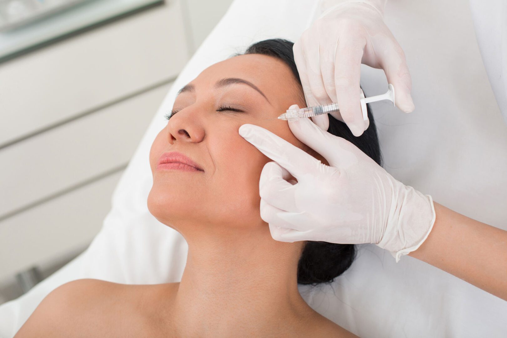 A woman getting her face waxed by an esthetician.