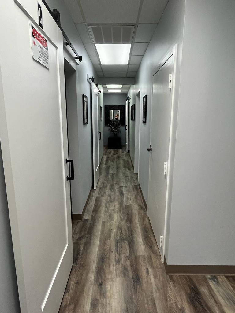 A hallway with many doors and some lights
